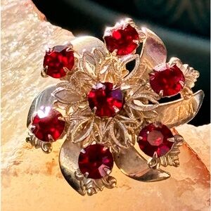 A Vintage Gold Toned Pinwheel Brooch with Red Rhinestones